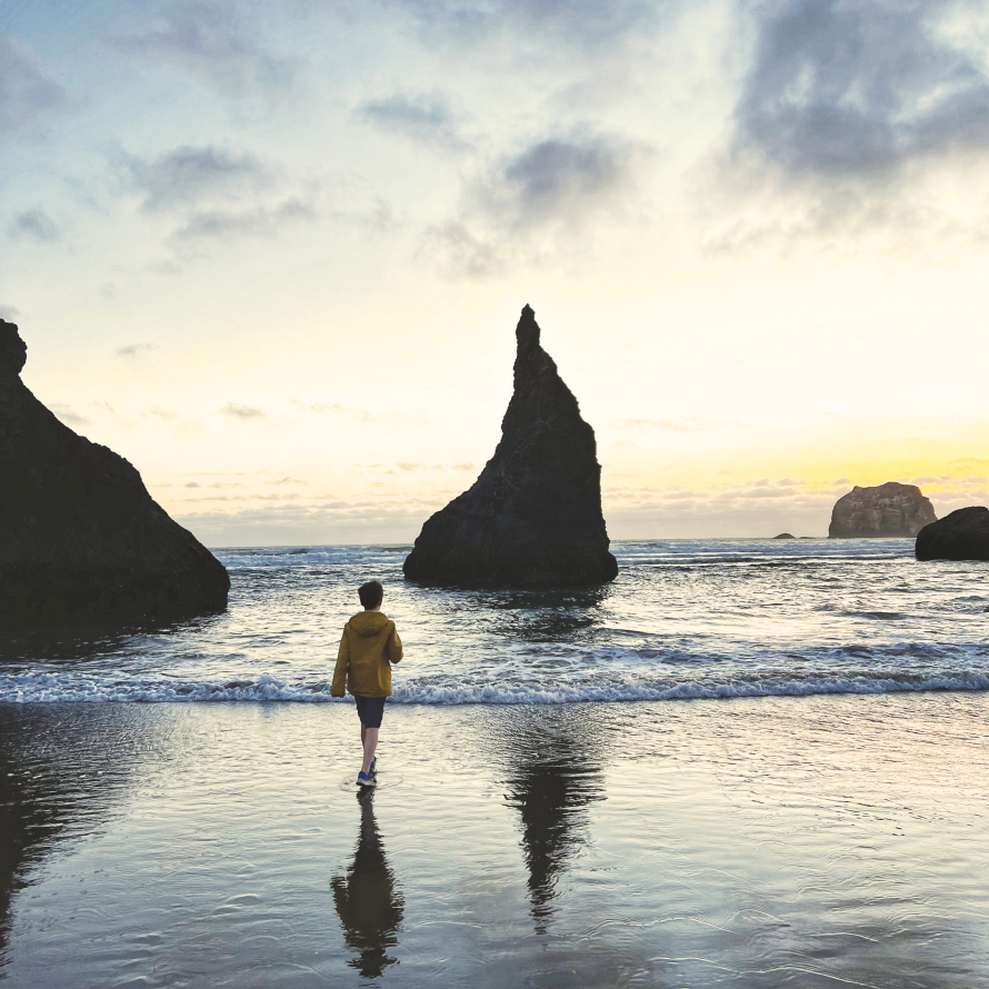Face Rock at sunset with young boy walking along the coast