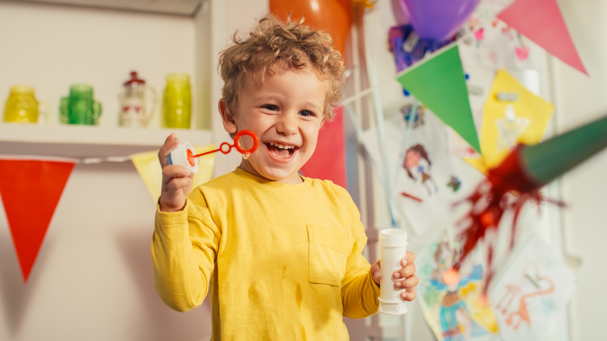 Child playing with bubbles and smiling