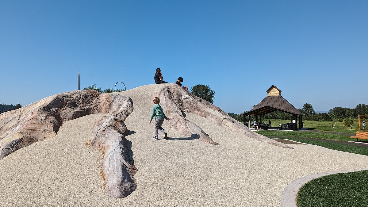A play mountain modeled after Mount Rainier is the central feature of newly opened Van Doren’s Landing Park playground in Kent, near Seattle. A boy scales the side of the mini mountain while playing at the playground.