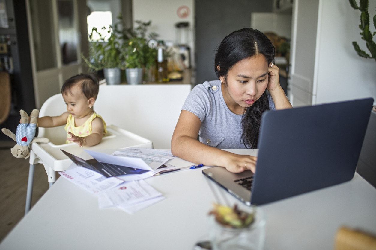 overwhelmed young mom trying to work from home while caring for a baby