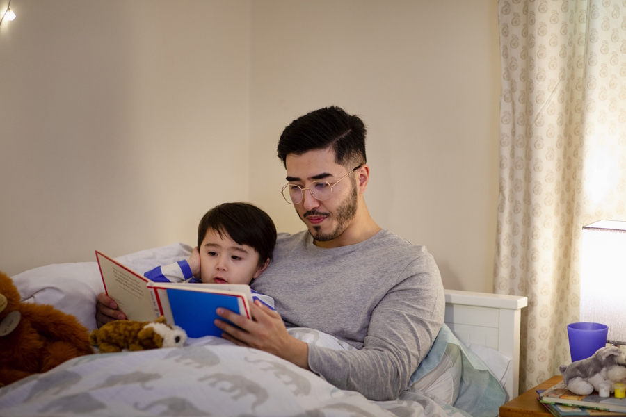 dad reading to a child in bed