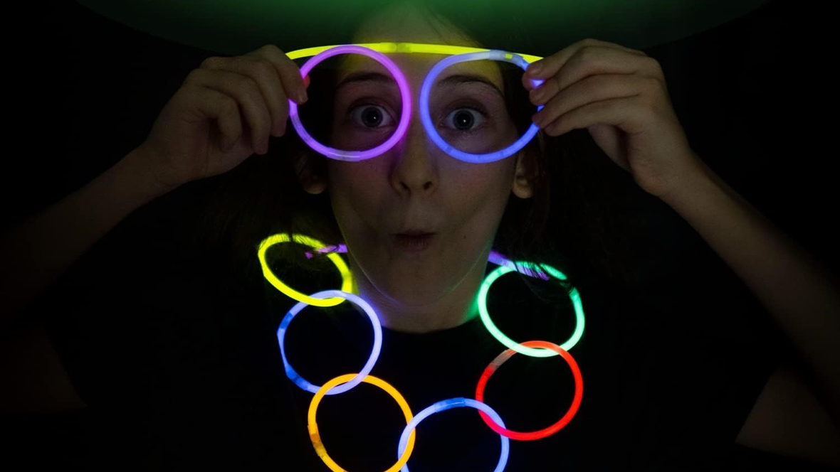 Girl with glow sticks on her eyes and as a necklace