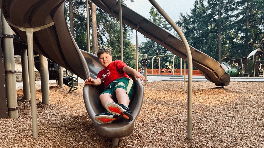 Sliding down the curly slide at West Seattle's newest playground in Lincoln Park