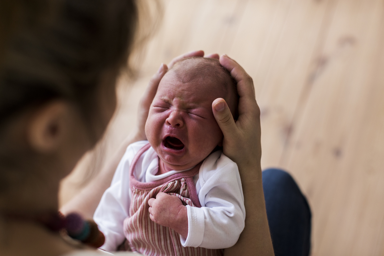 mother holding her crying newborn