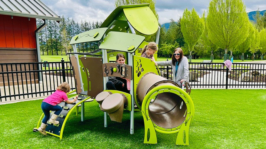 Kids climb, slide and play on the smaller structure at a new Snoqualmie playground.