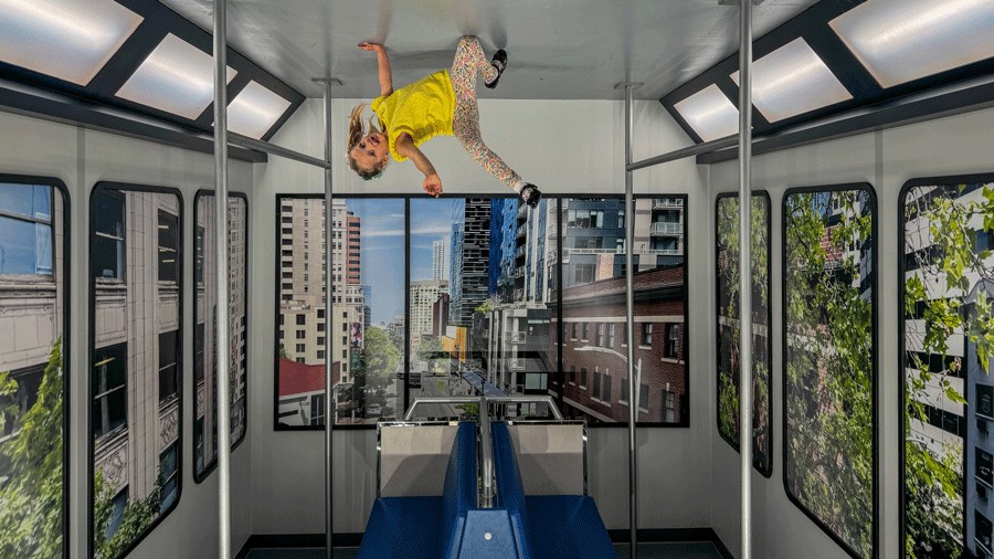 Young girl pretends to be an upside down comic book character at Museum of Illusions Seattle