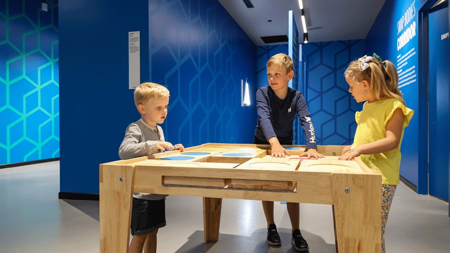 Three kids playing an interactive game at Museum of Illusions Seattle