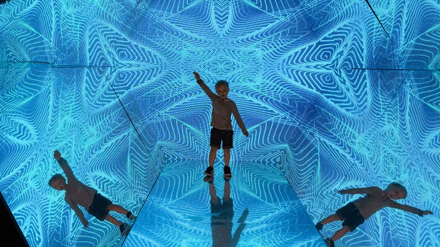 young boy poses in the Kaleidoscope Room at Museum of Illusions Seattle