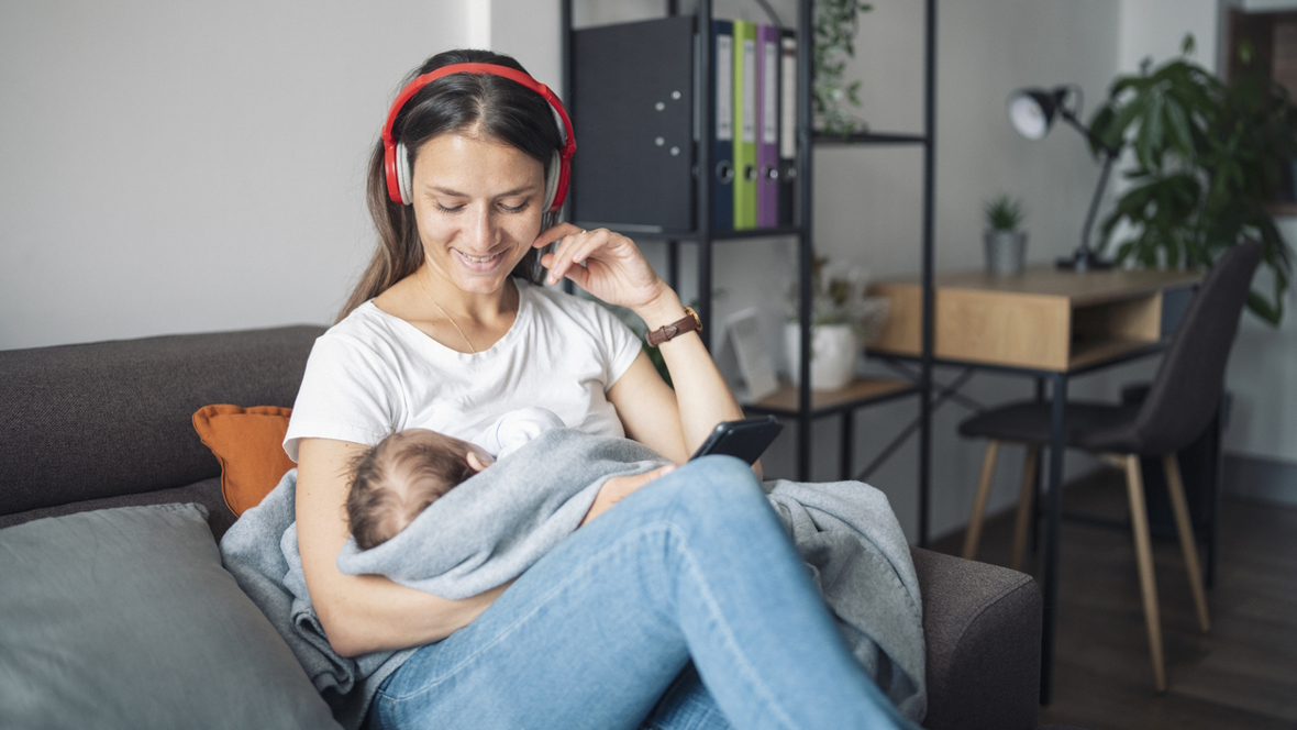 mom holding a baby and listening to a parenting podcast