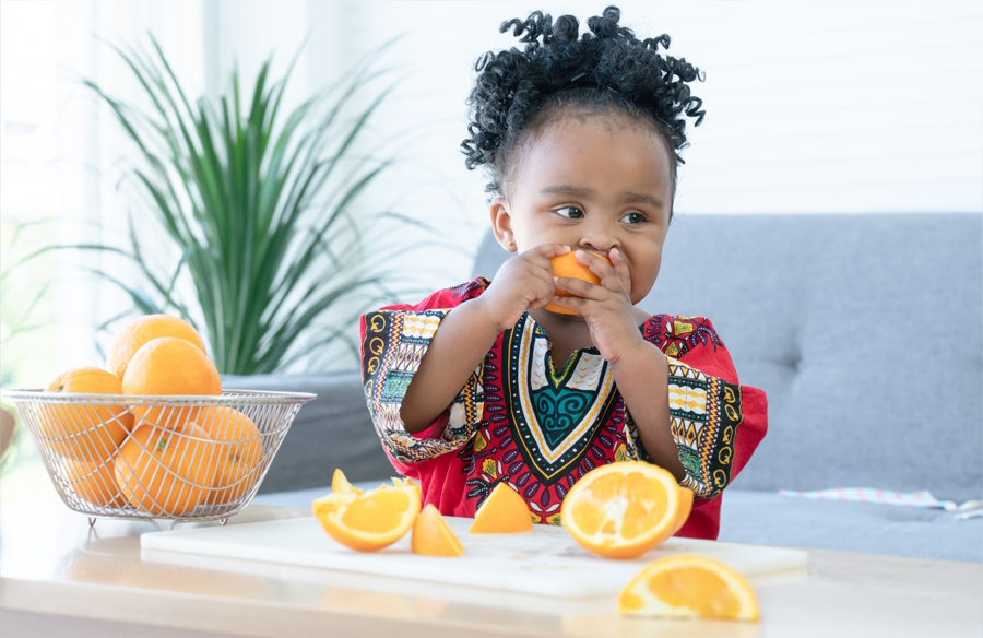 Little girl eating a snack that is cut up into slices can help reduce food waste