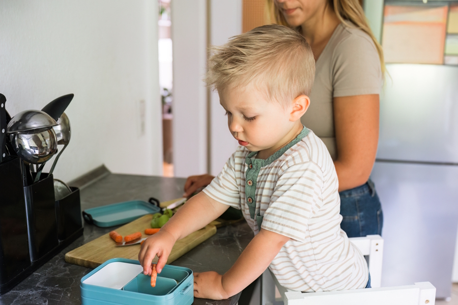 Young child helping prepare their lunch to help reduce food waste