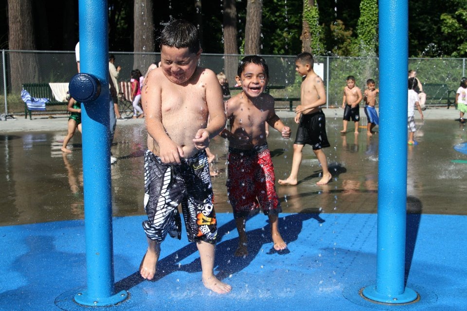 Happy kids playing at Forest Park in Everett's water playground open for summer