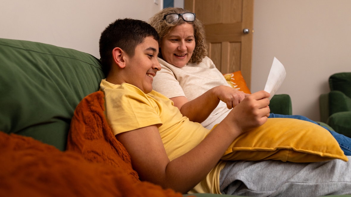 mom and son sitting on a couch happy together