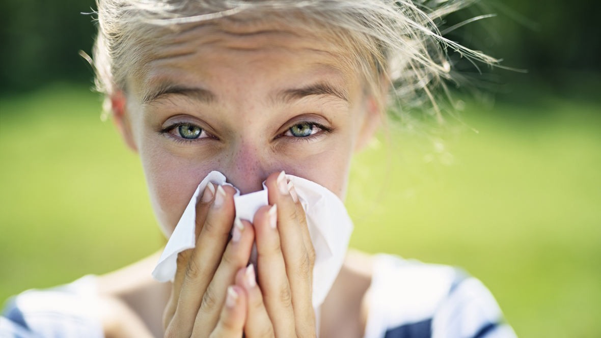 girl sneezing who has environmental allergies and needs immunotherapy