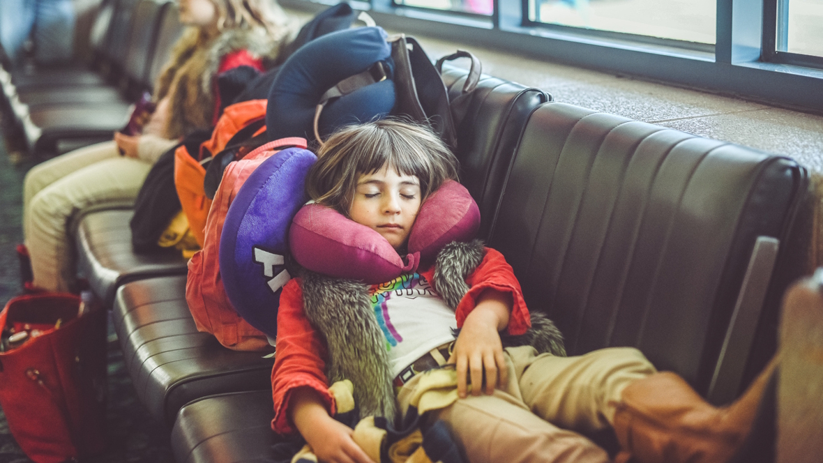 child sleeping at the airport with jet lag