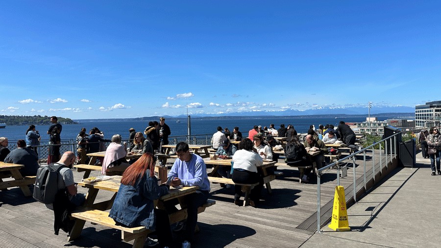 People eating outside at the Pike Place Marekt in Seattle with kids on a sunny day