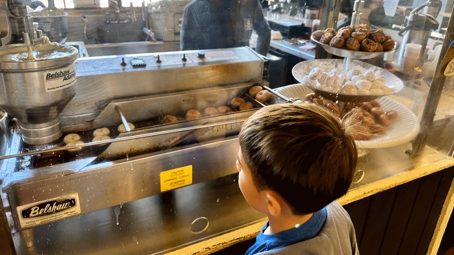 A boy watching donuts being make at Pike Place Market in Seattle