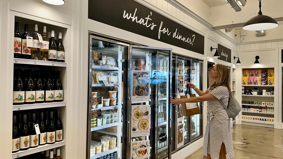 A woman standing in front of the freezer section at Kitchen and Market in Pike Place Market Seattle