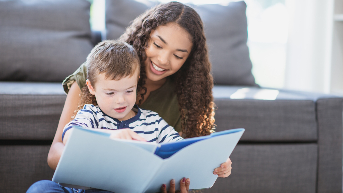 Teenage babysitter reading a book with a child how much to pay your babysitter