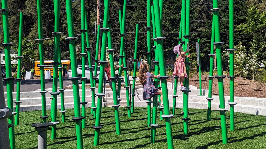 Two kids climbing bamboo-inspired poles at Bridle Trails Valley Creek Park