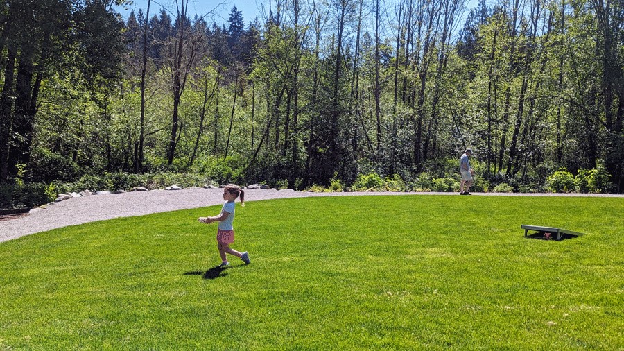 Small child plays lawn games at Bridle Trails Valley Creek Park