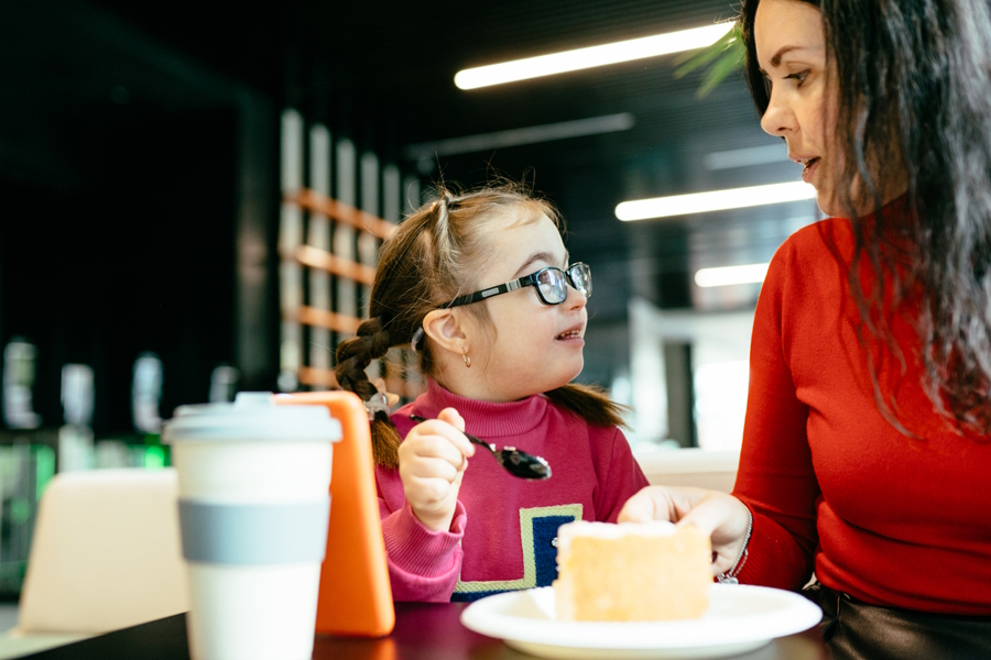A girl and her mother enjoying some cake at a kid-friendly coffee shop