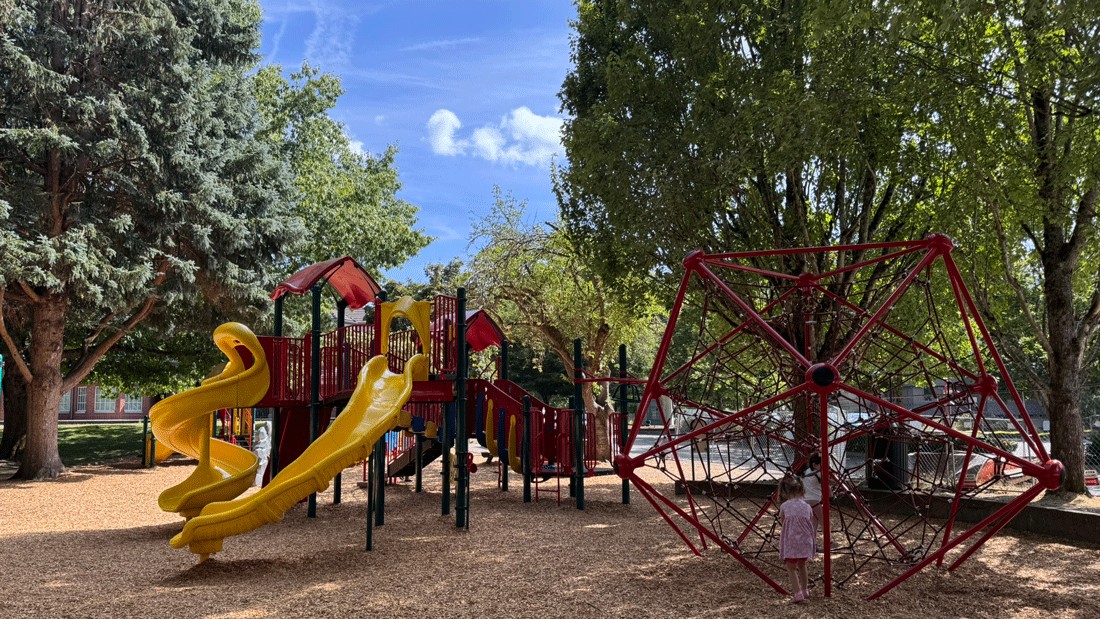 kids playing in the shade on the playgroudn by Veterans' Memorial Field