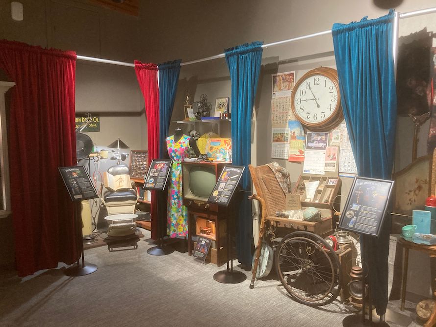 wide snapshot of the closets of curiosity exhibit with red and blue curtains framing the displays