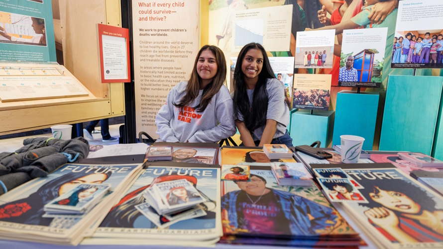 Girls sitting at an info table at the Teen Action Fair Gates Foundation Discover Center