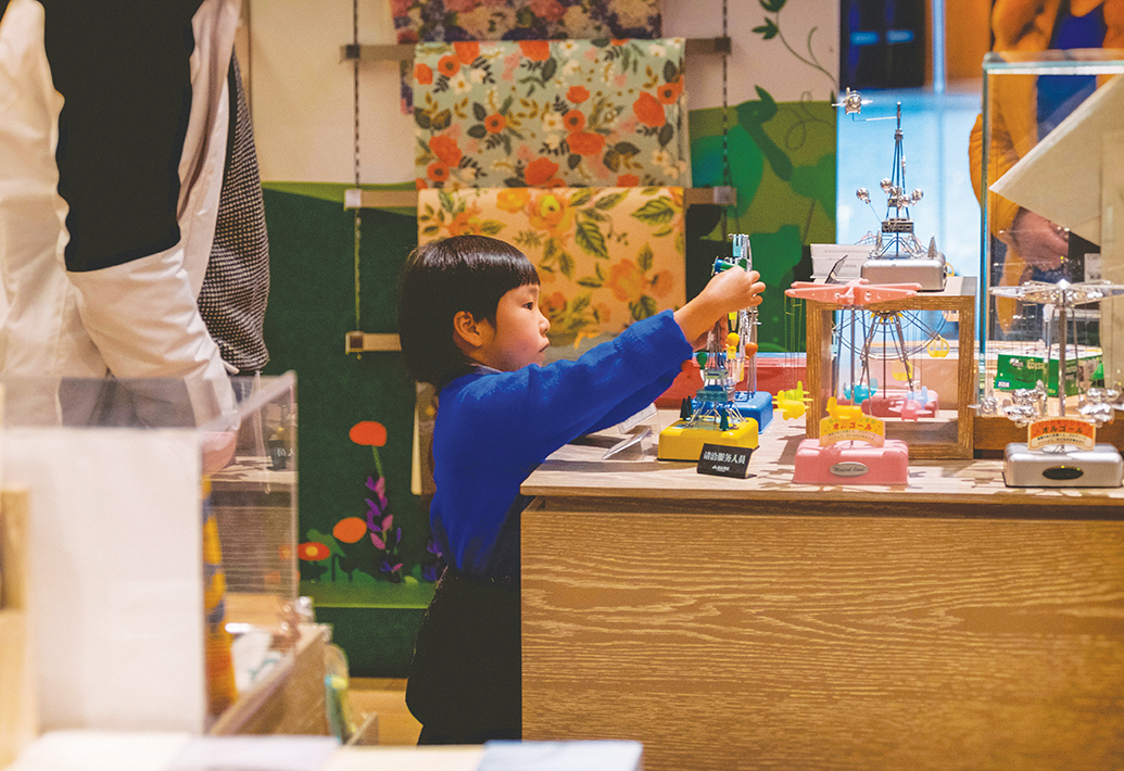 A young Asian child concentrates on a project in a Montessori classroom