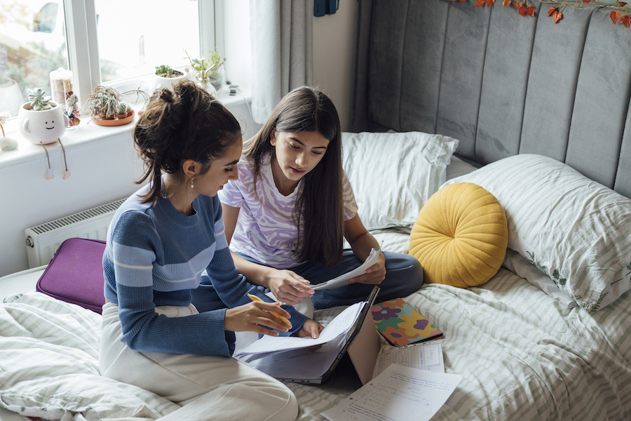 two students engage in peer tutoring together at a home