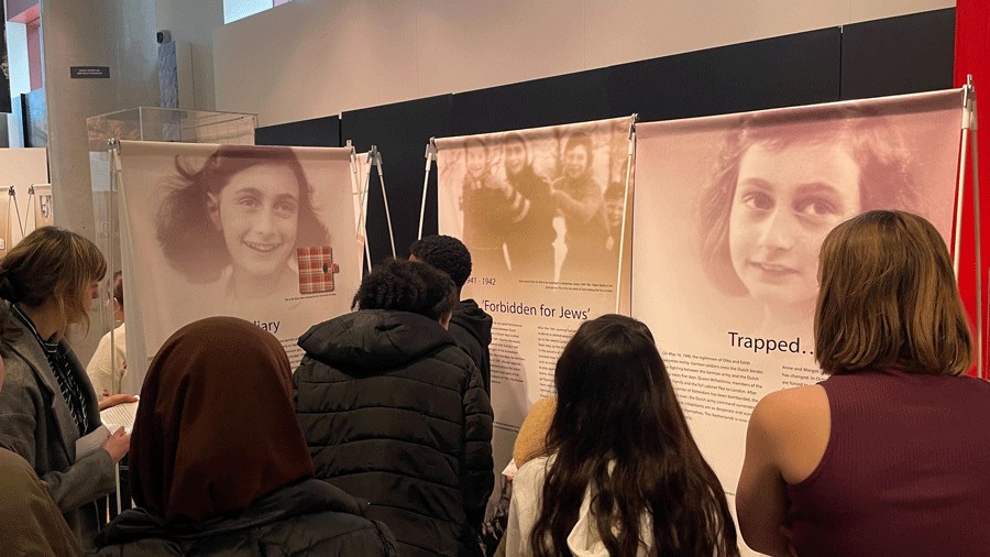 museum visitors learning about the life of Anne Frank through panels and images during a traveling exhibition at the Holocaust Center for Humanity
