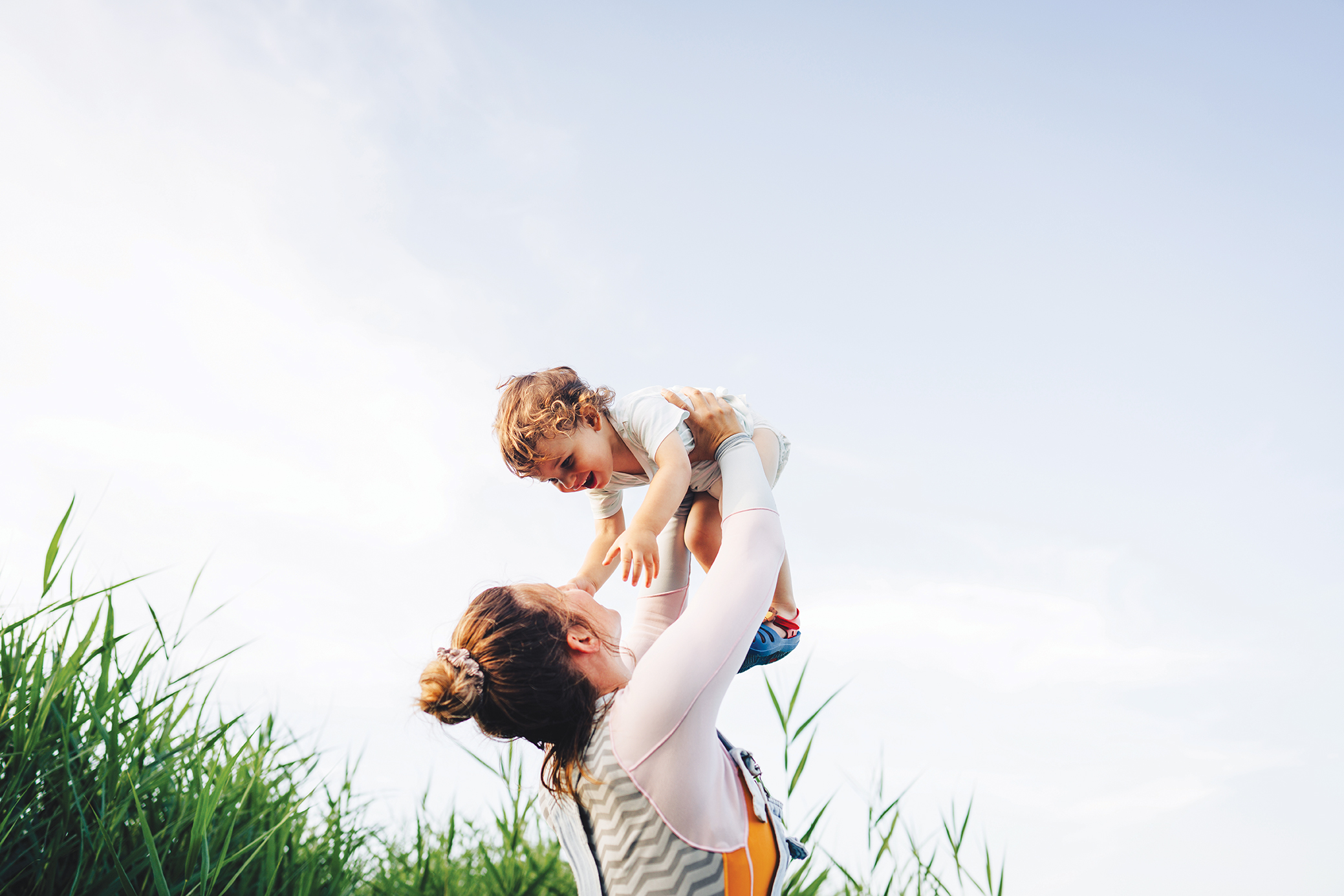 Women lifting smiling child into the air
