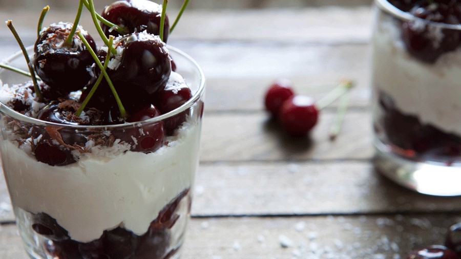 cottage cheese ice cream, a dessert superfood, sprinkled with coconut and topped with cherries