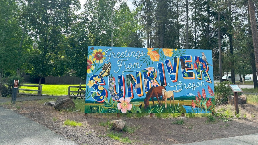 Welcome sign for Sunriver, Oregon with a floral mural