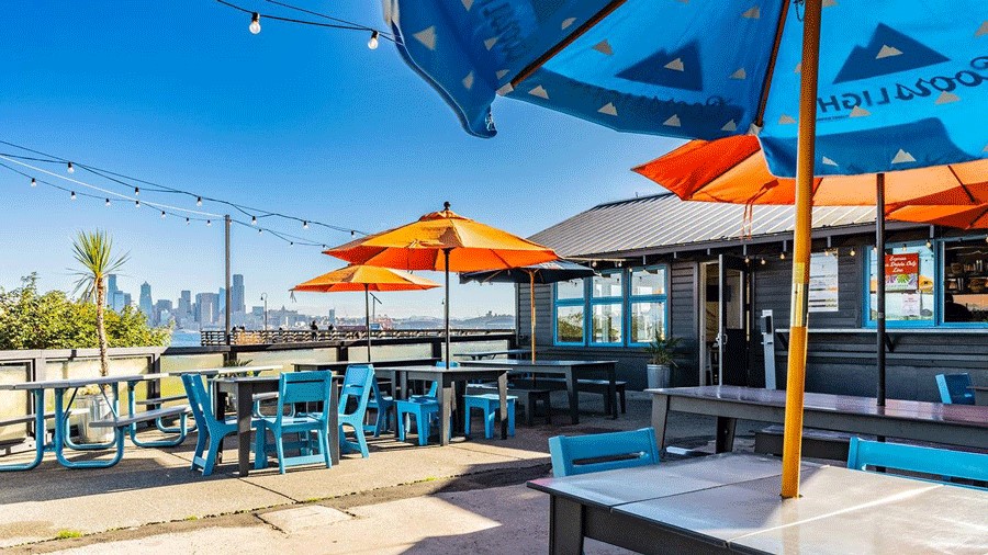 Colorful umbrellas on the waterfront dining area at Marination ma kai in Seattle
