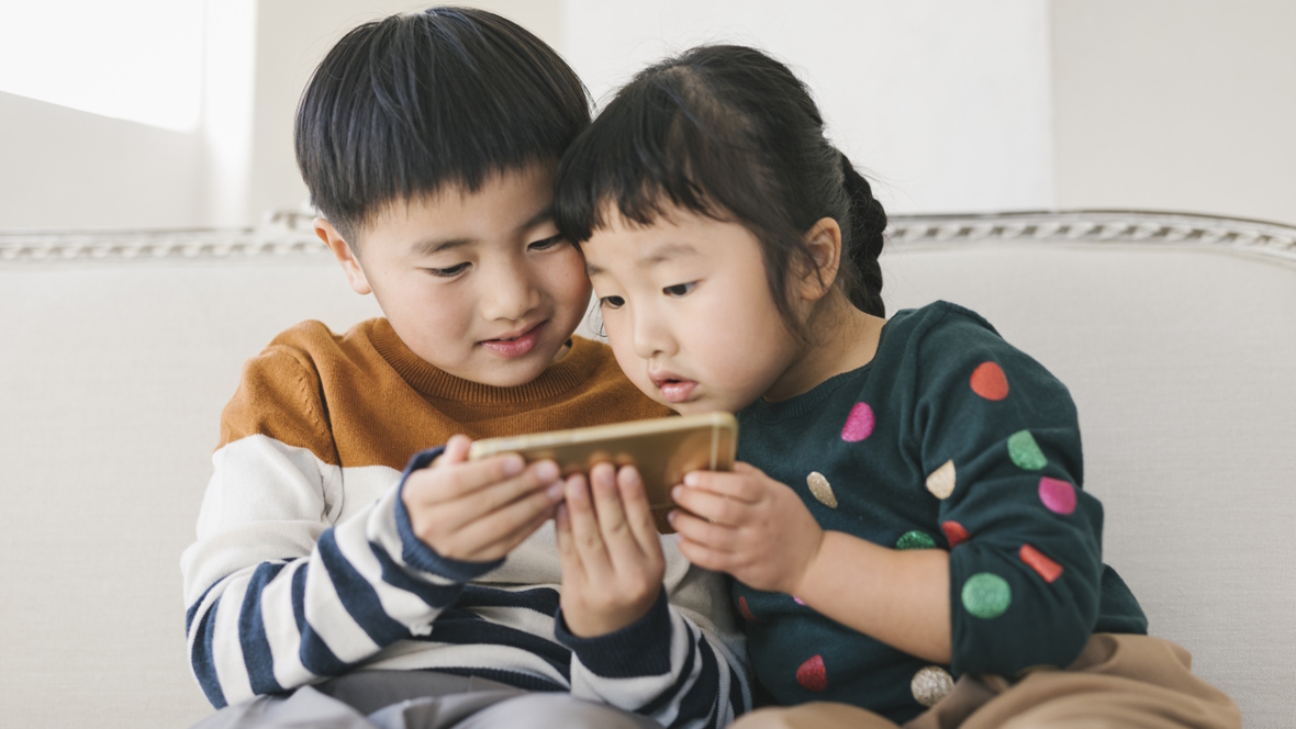 Brother and sister looking at a smart phone