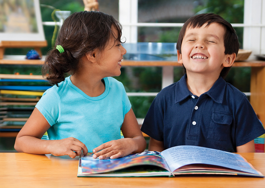 little kids looking at books and laughing