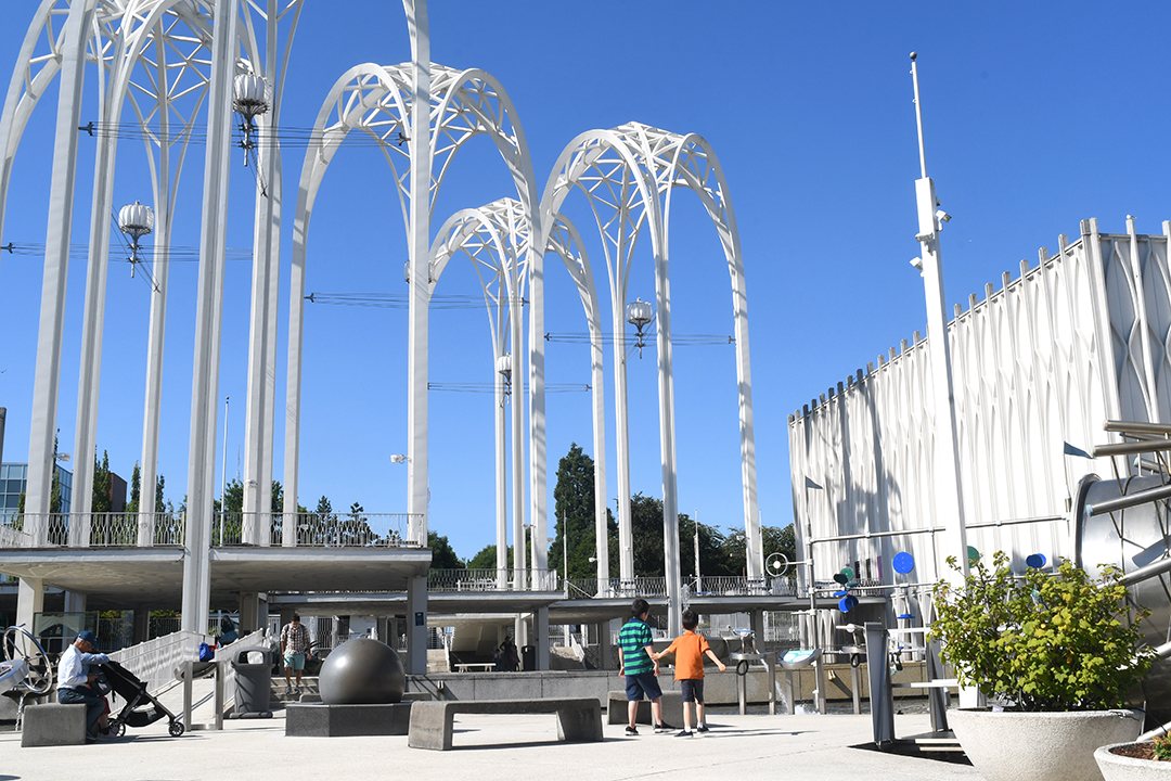 Boys play under the iconic arches of Seattle's Pacific Science Center, back open after more than two years