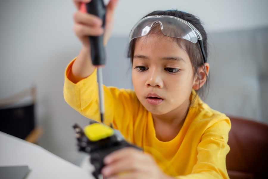 Girl fixing a problem at home with a screwdriver