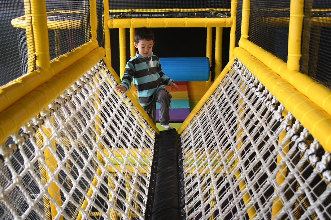 Seattle indoor playground Outer Space Seattle reopens for indoor play demonstrated by a boy navigating the large climber