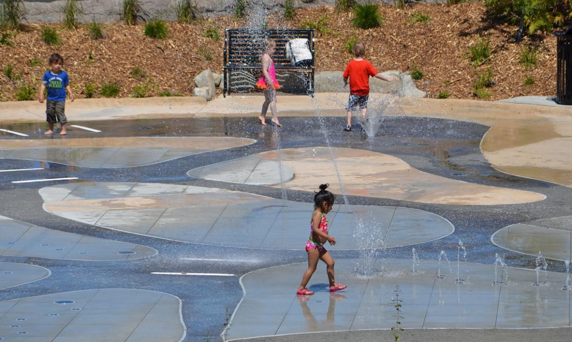 Young kids playing in the spray park at Jefferson Park in Seattle stay cool in a Seattle heat wave