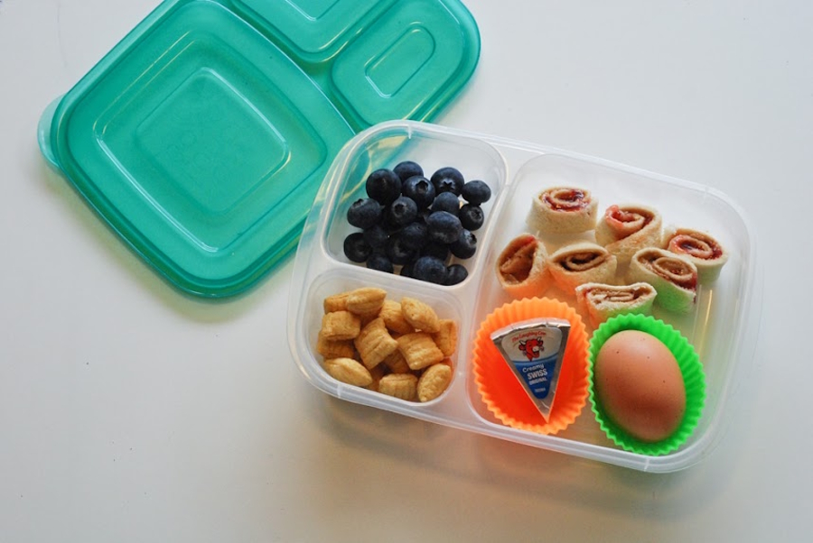 lunch box with wraps, cheese, blueberries, crackers and a hard boiled egg