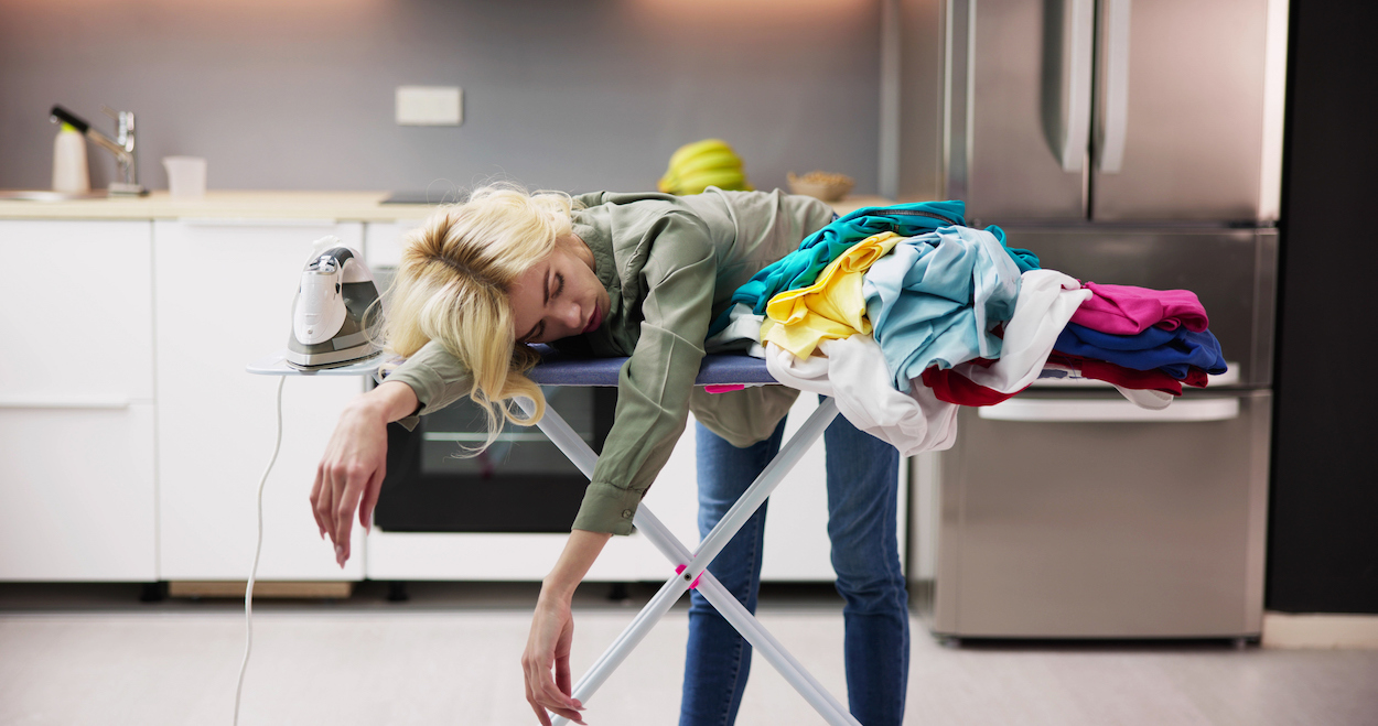 exhausted mom on laundry pile