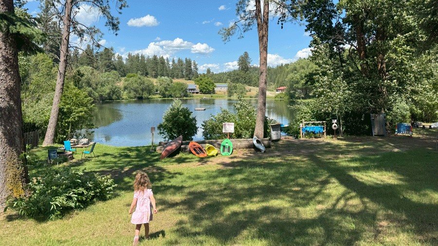 young child walking toward Blue Lake with kayaks and recreational activities