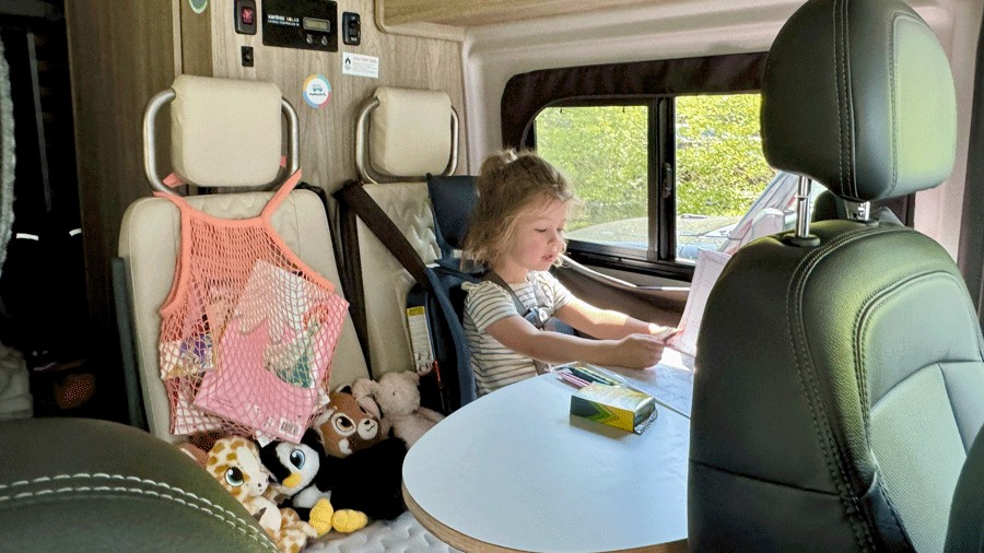 young child coloring in her seat in a roadsurfer Liberty Lodge model