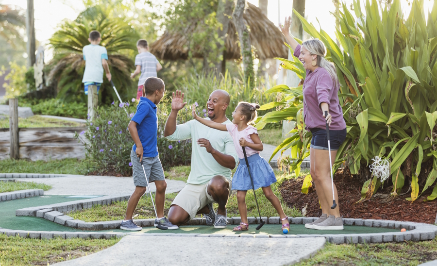 a happy family on a mini golf course