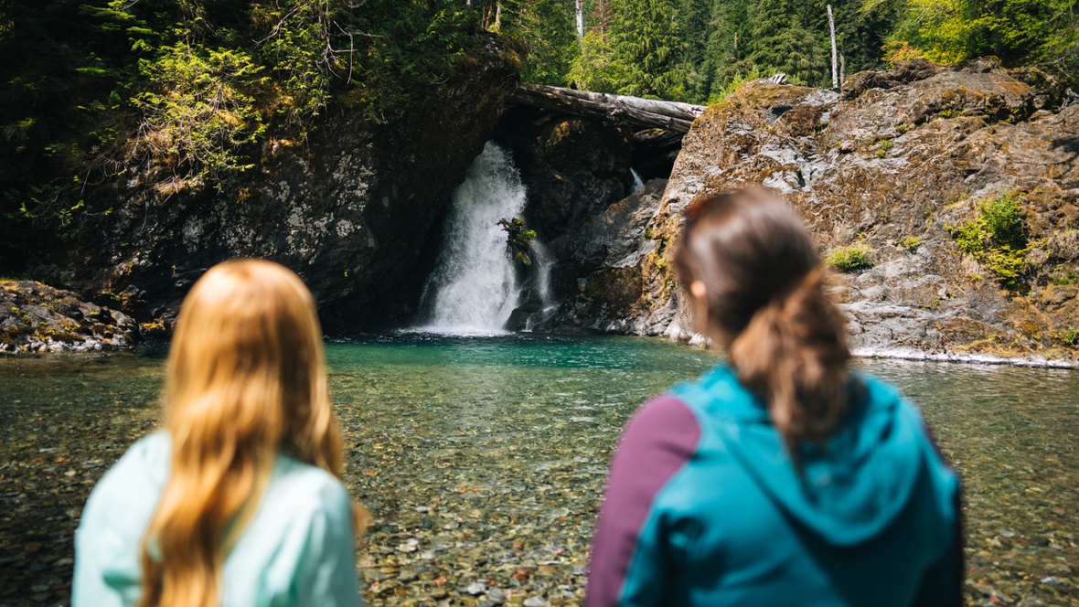 Two women looking at a waterfall in Washington