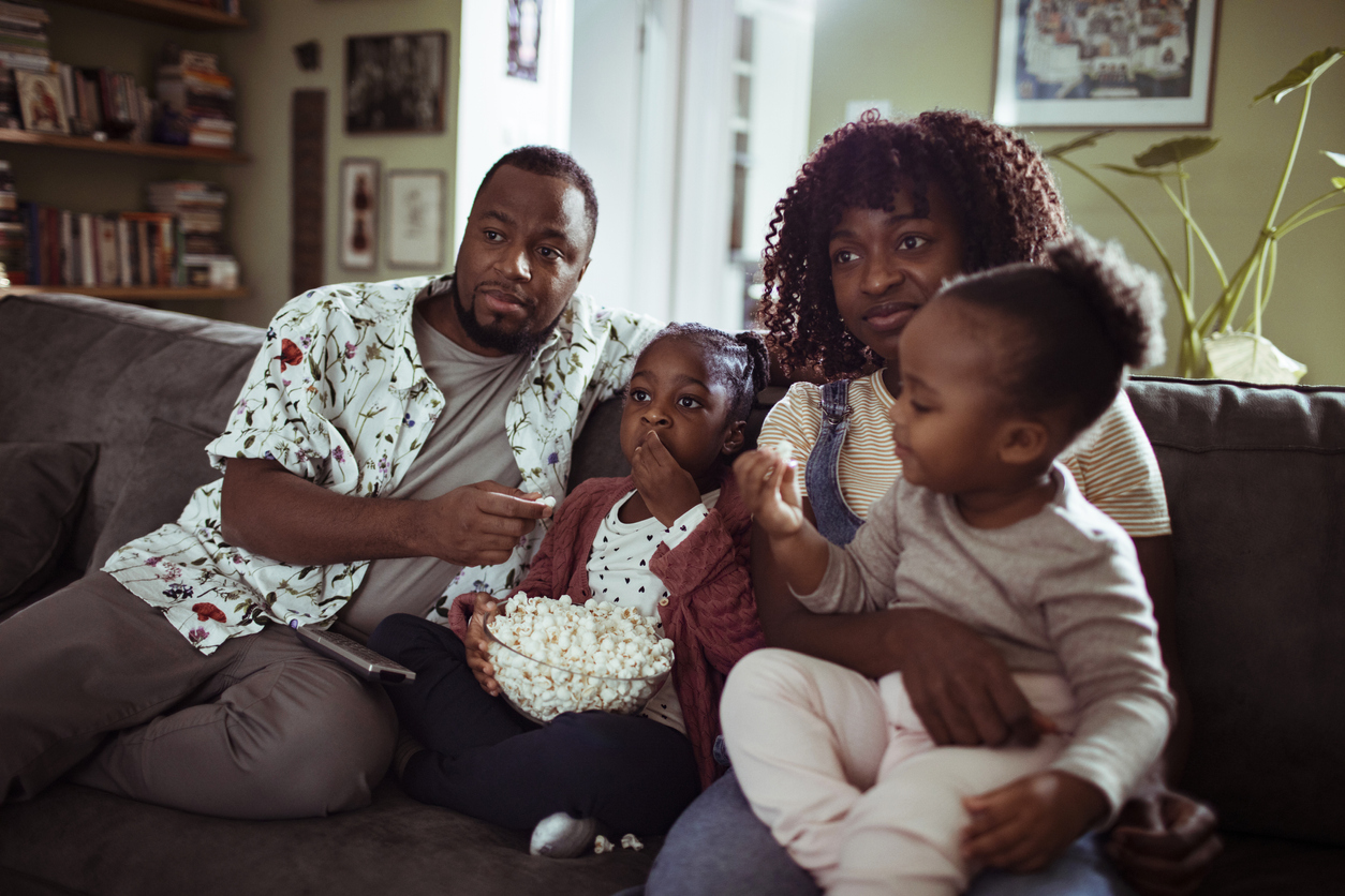 family of four sitting on the couch with popcorn