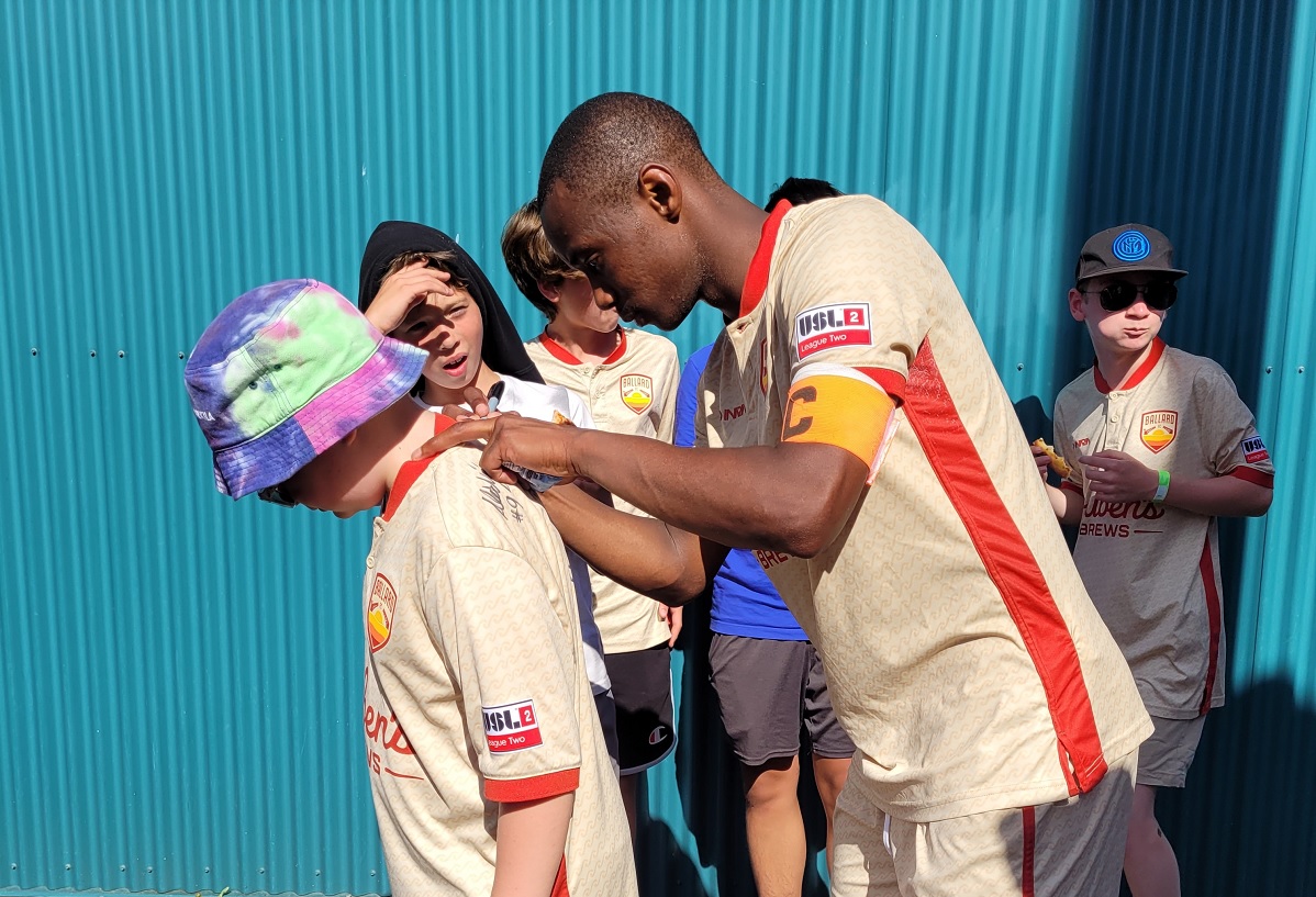 Ballard FC player Lesia Thetsane signs the jersey of a young fan at a 2022 Ballard FC match